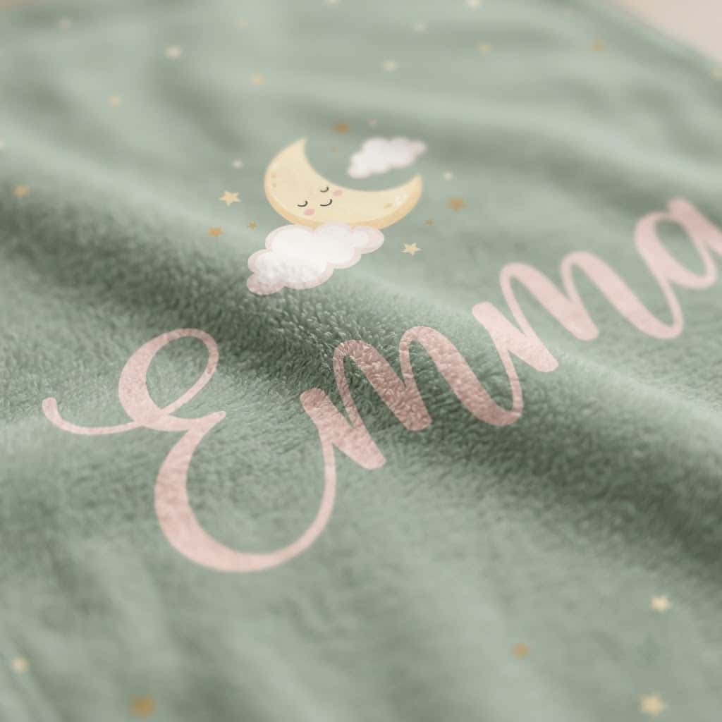 Close-up of blush Emma script and crescent moon on flannel