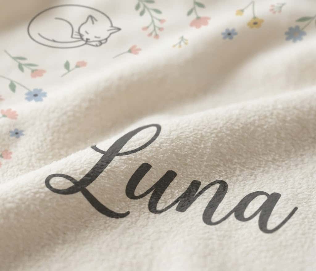 Detail of the Luna script name and line-art cat printed on soft flannel