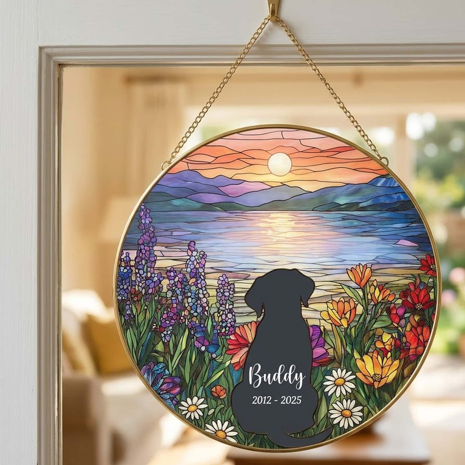 Dog memorial suncatcher with Buddy 2012 - 2025 hanging in a sunny window