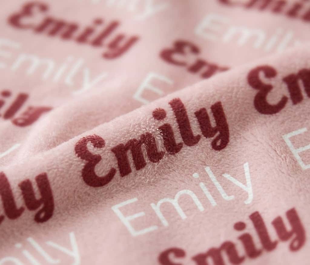 Close-up of Emily rows in rose script and white letters on blush flannel