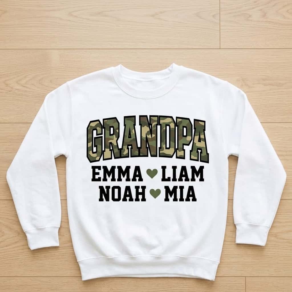 White grandpa camo sweatshirt laid flat on light wood with four grandkids names