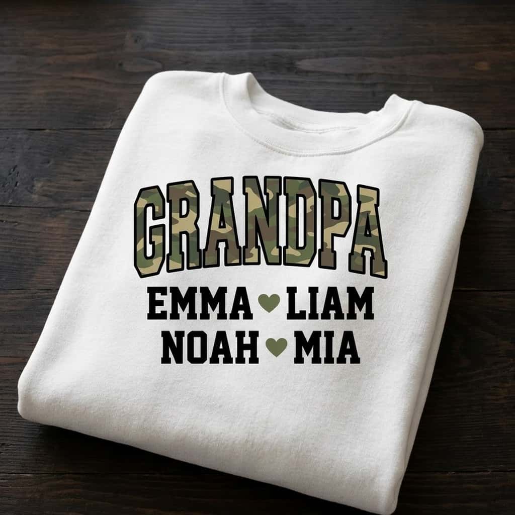 Folded camo Grandpa sweatshirt on a dark table showing Emma, Liam, Noah, Mia