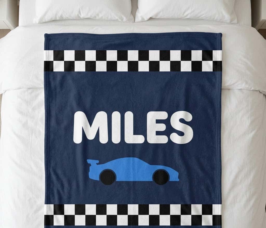 Race car name blanket with MILES and a blue car, flat on a bed