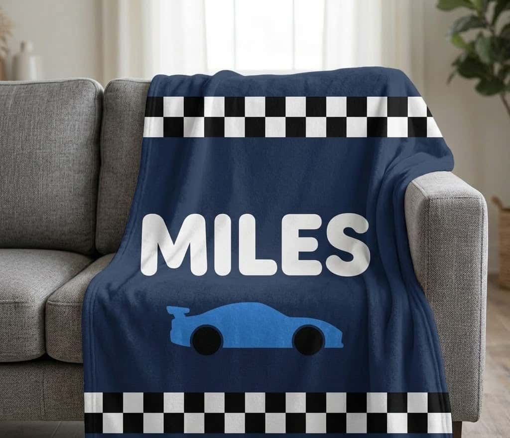 MILES race car name blanket draped over a gray sofa arm