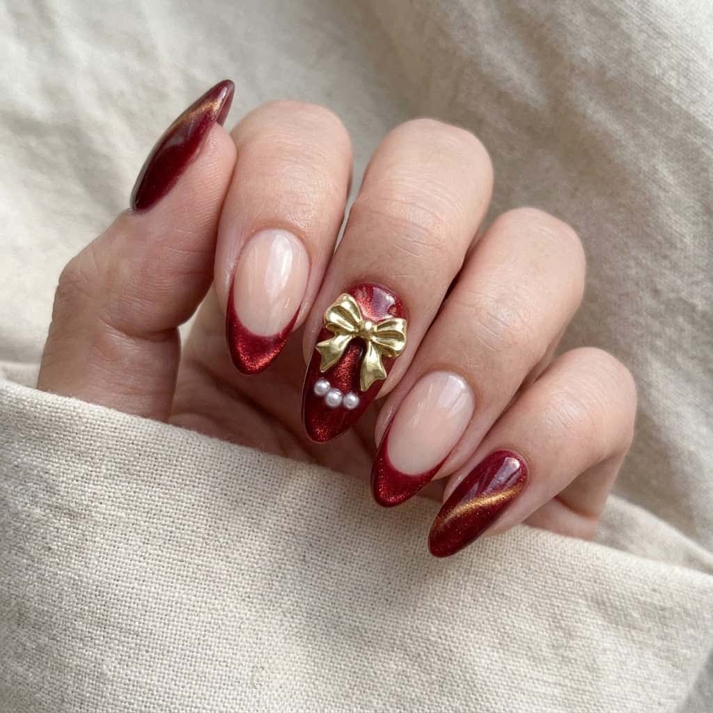 Hand wearing red cat eye Christmas press on nails with gold bow