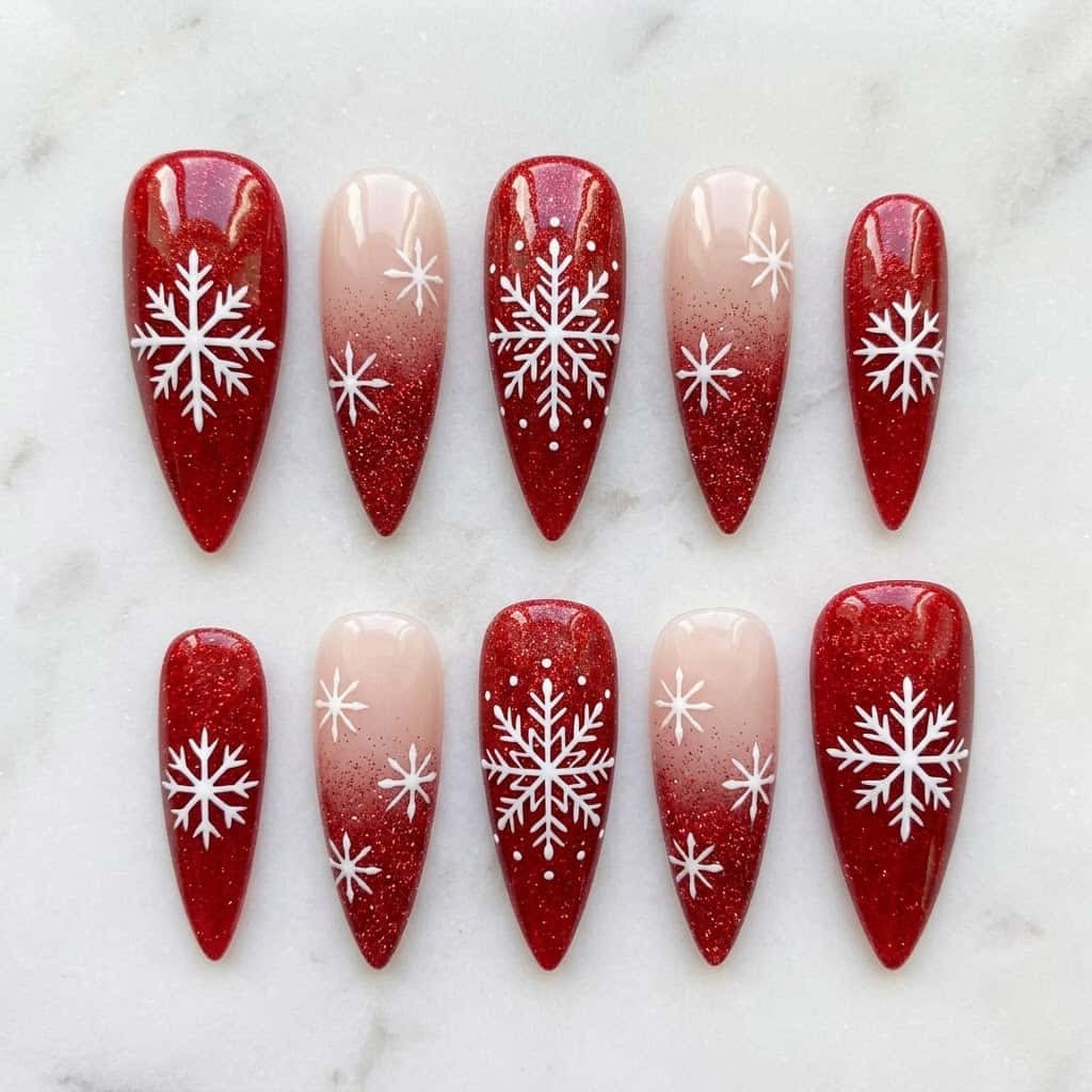 Red snowflake nails, ten long stiletto nails in two mirrored rows on white marble