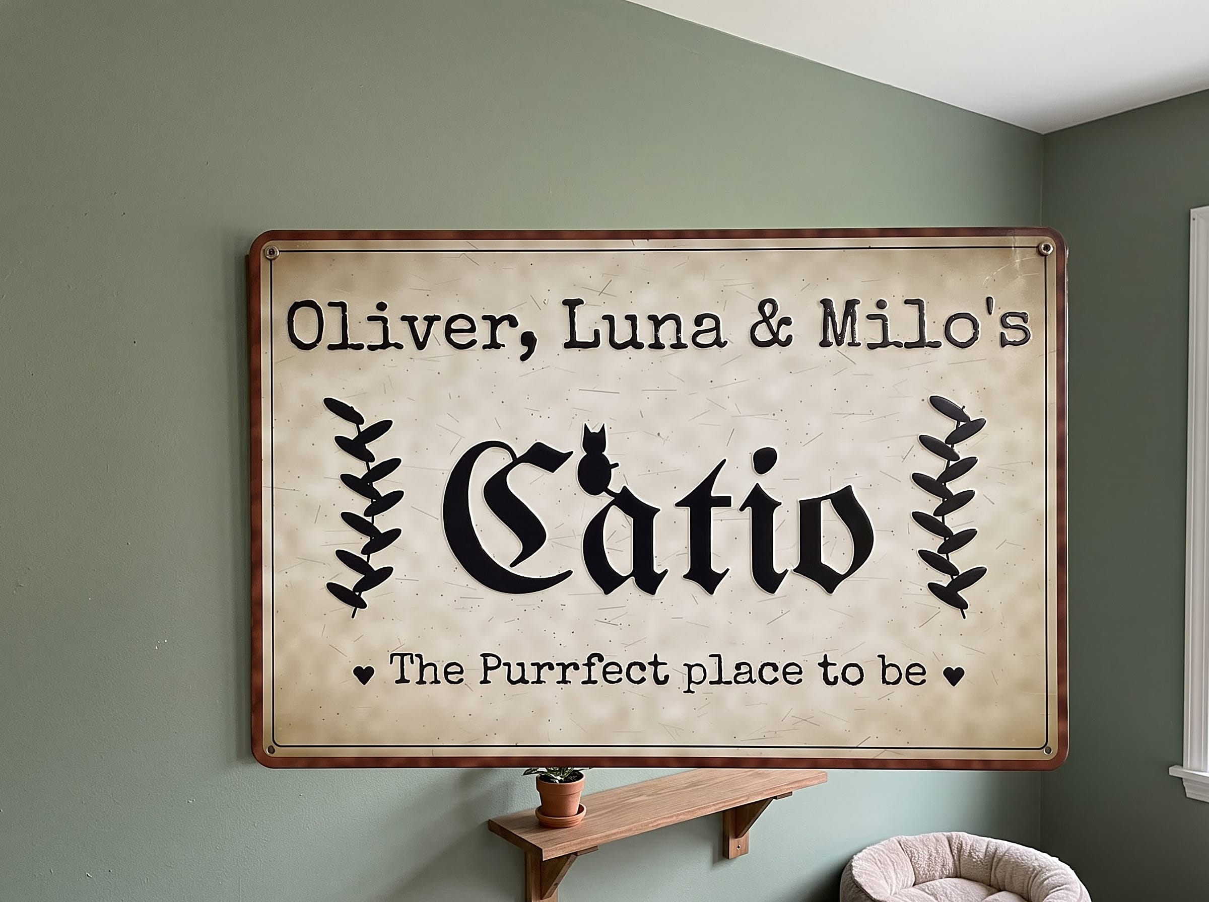 Vintage Catio metal sign above a cat bed on a sage green wall