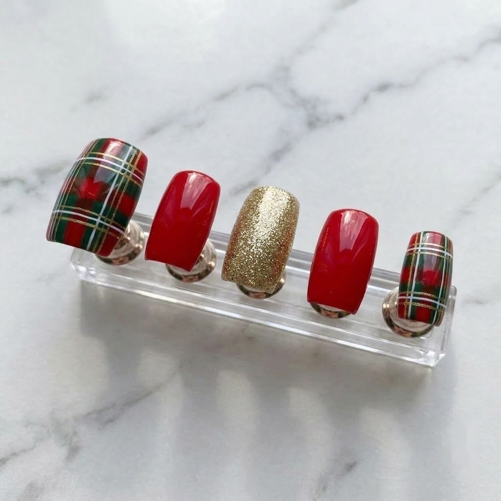 Five christmas plaid press on nails on a clear acrylic nail stand