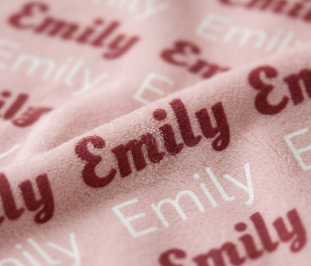 Close-up of Emily rows in rose script and white letters on blush flannel
