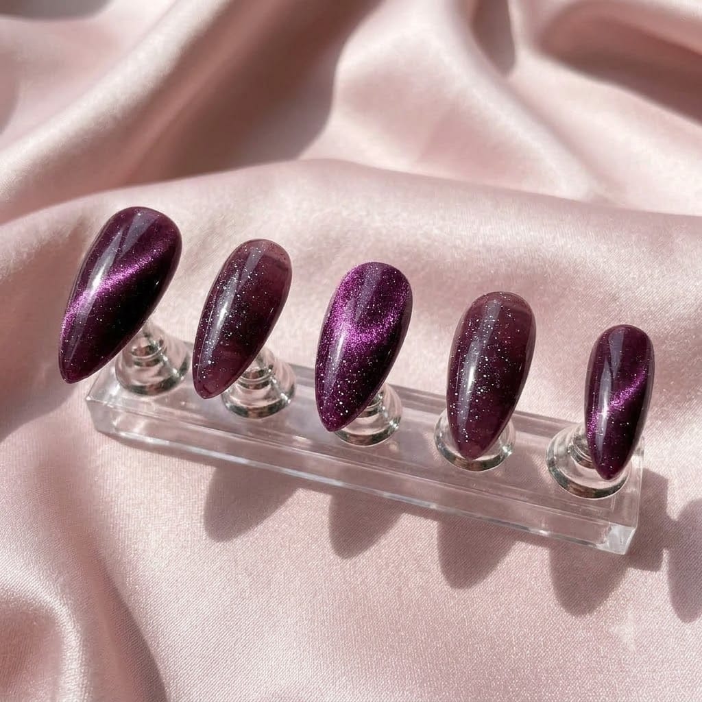 Five glitter cat eye nails on a clear acrylic stand