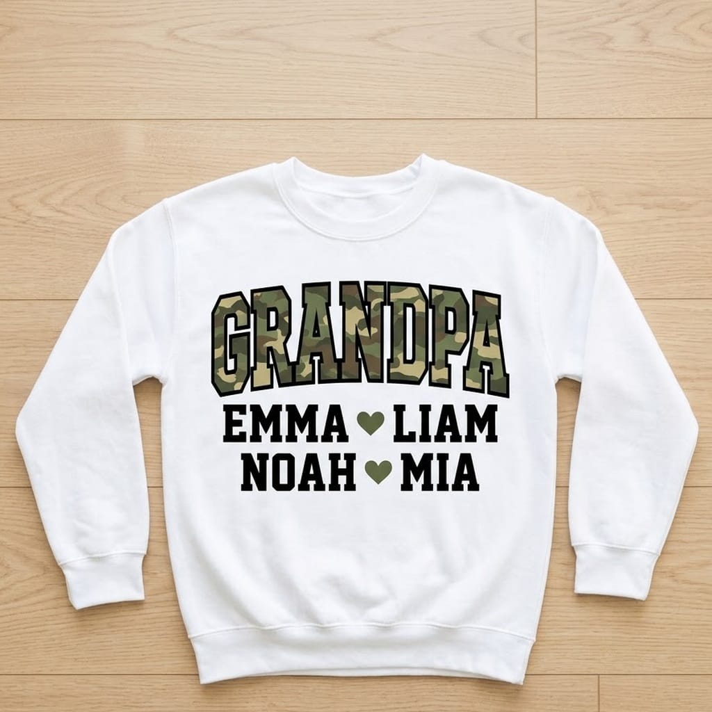 White grandpa camo sweatshirt laid flat on light wood with four grandkids names
