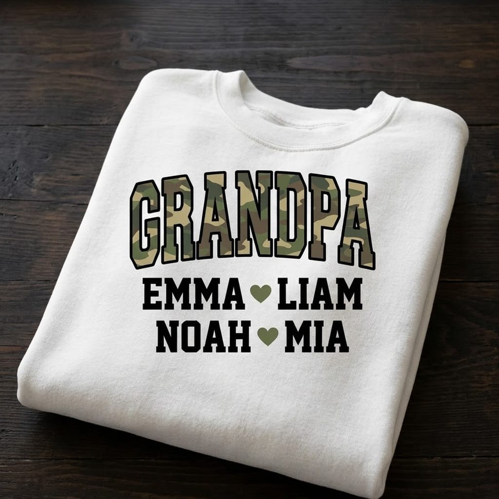 Folded camo Grandpa sweatshirt on a dark table showing Emma, Liam, Noah, Mia